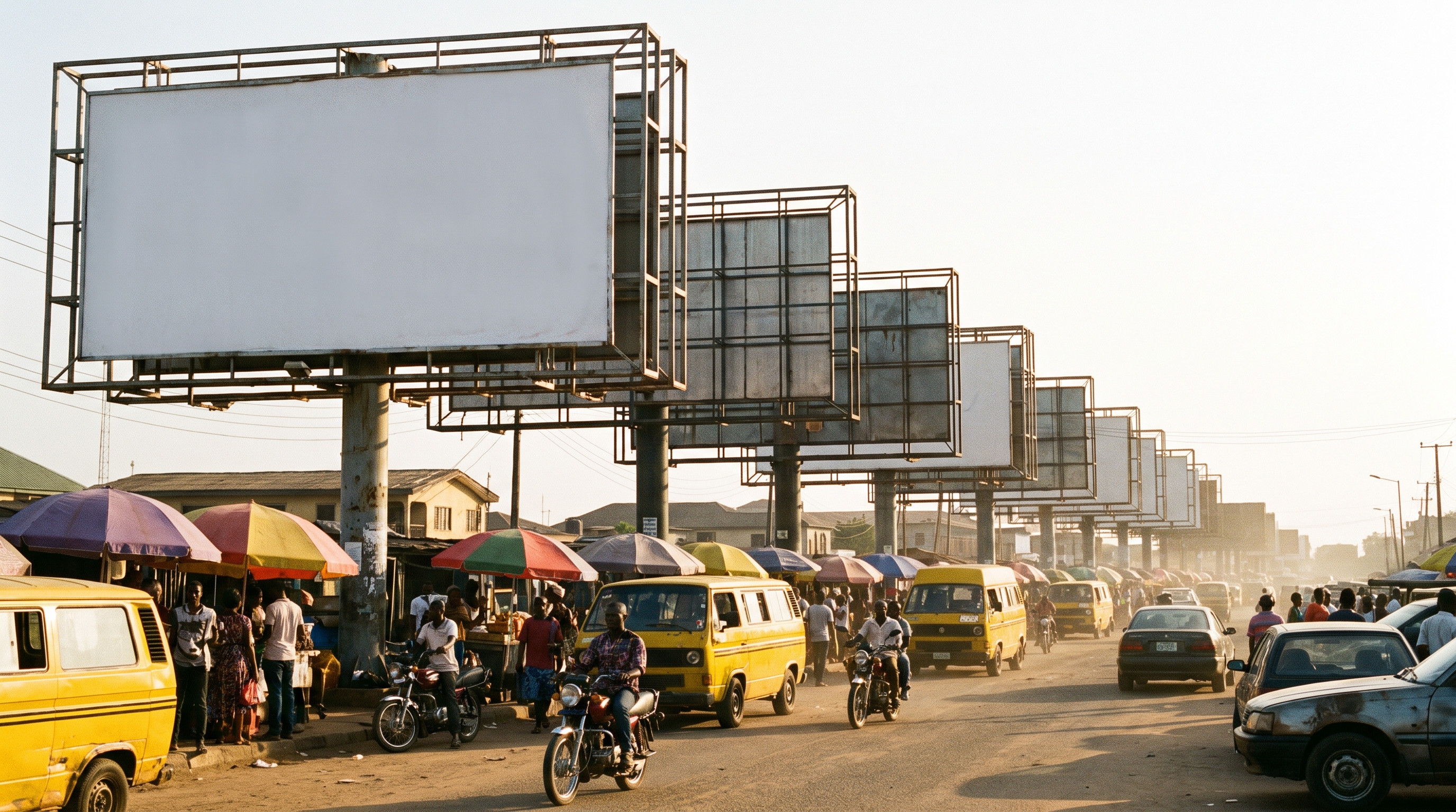 A row of blank billboards standing over a busy Nigerian street